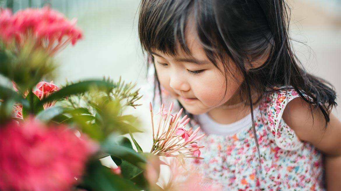 Petite fille respirant l'odeur d'une fleur